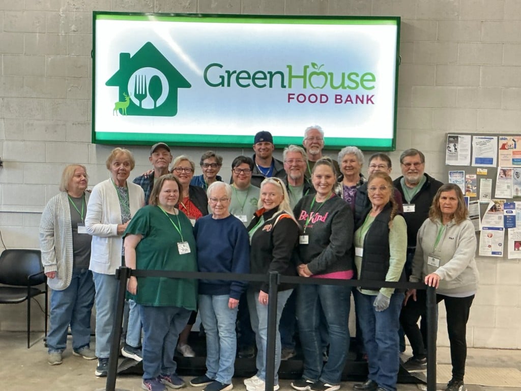 GreenHouse Food Bank volunteers and staff in front of the warehouse sign